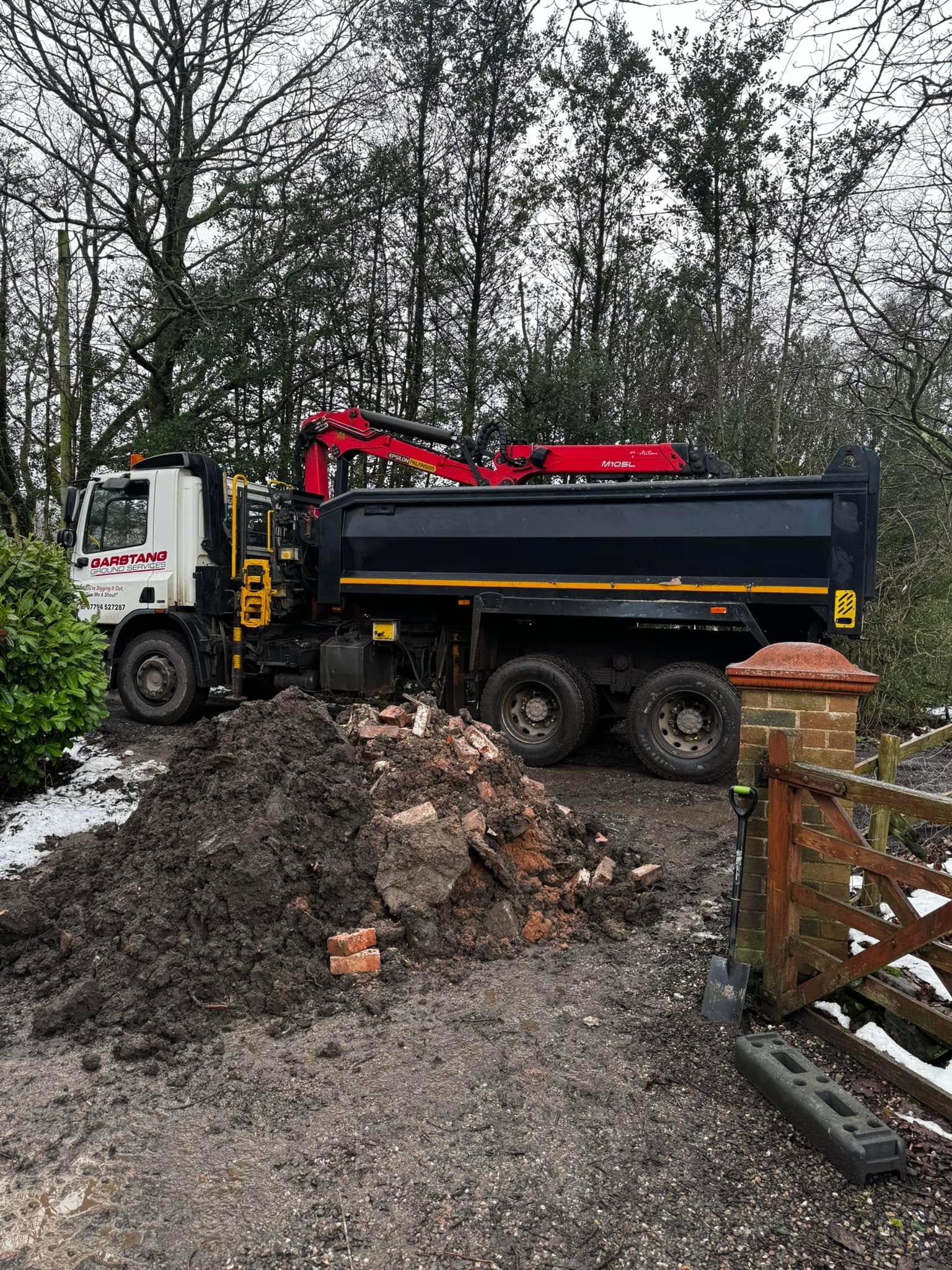 Grab lorry loading inert waste during construction site clearance
